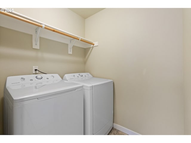 laundry room with laundry area, baseboards, light tile patterned floors, and washing machine and clothes dryer