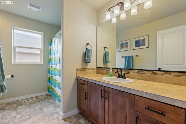 bathroom featuring baseboards, visible vents, decorative backsplash, and vanity