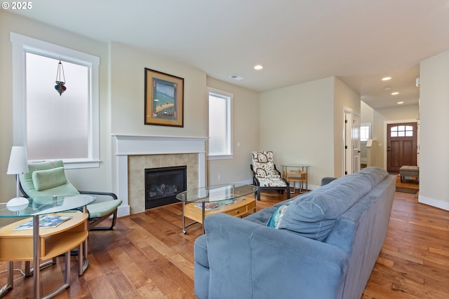 living room featuring recessed lighting, baseboards, wood finished floors, and a fireplace