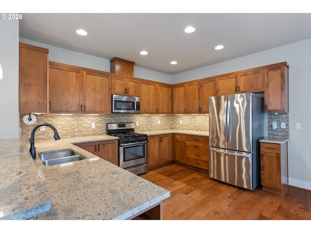 kitchen featuring a sink, stainless steel appliances, and brown cabinets