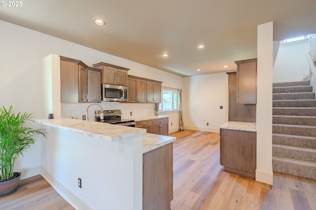 7906 SE Woodstock Blvd, Portland, OR 97206 - kitchen featuring stainless steel appliances, light countertops, tasteful backsplash, light wood finished floors, and recessed lighting