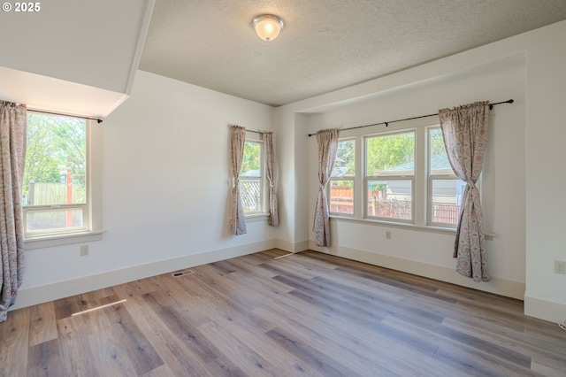7906 SE Woodstock Blvd, Portland, OR 97206 - spare room with wood finished floors, a textured ceiling, and baseboards