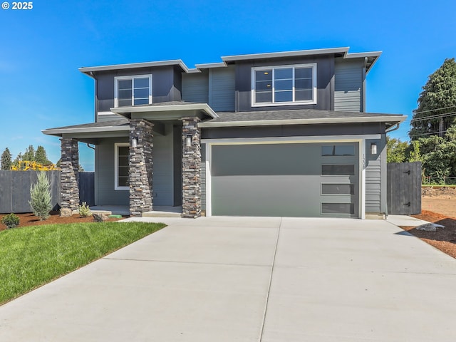 1208 N 44th Pl, Ridgefield, WA 98642 - prairie-style home with a porch, a garage, fence, and concrete driveway