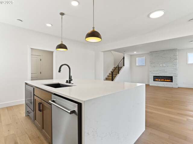 1208 N 44th Pl, Ridgefield, WA 98642 - kitchen with stainless steel dishwasher, pendant lighting, light wood-style floors, light countertops, and a sink