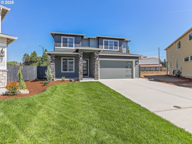 1208 N 44th Pl, Ridgefield, WA 98642 - prairie-style home with fence, stone siding, a garage, a front yard, and concrete driveway