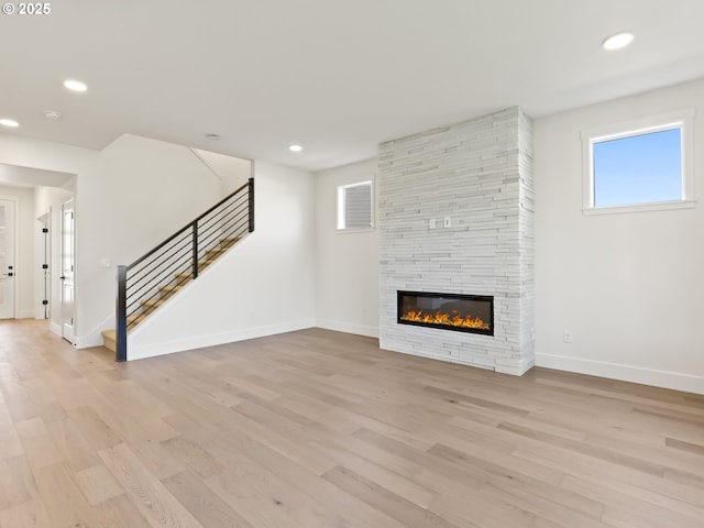 1208 N 44th Pl, Ridgefield, WA 98642 - unfurnished living room featuring light wood-style floors, baseboards, stairway, and recessed lighting