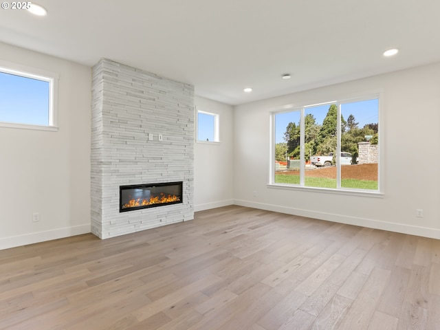1208 N 44th Pl, Ridgefield, WA 98642 - unfurnished living room with recessed lighting, baseboards, a fireplace, and light wood finished floors