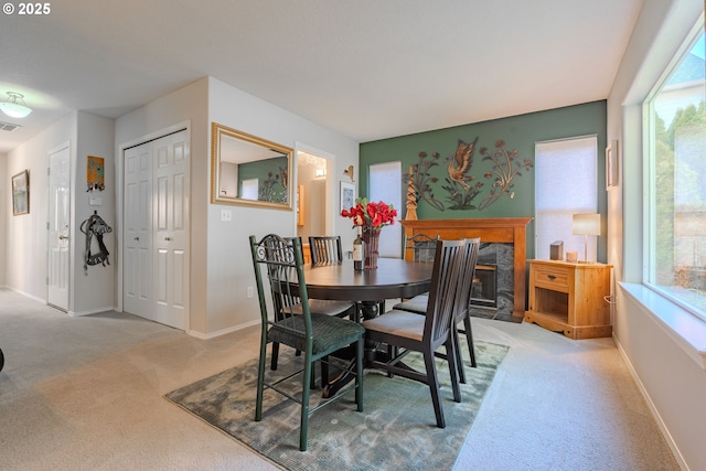 carpeted dining space featuring a premium fireplace