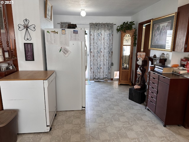 309 E Van Buren St, Athena, OR 97813 - kitchen with freestanding refrigerator, refrigerator, dark countertops, and stone finish floors