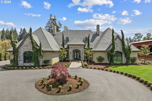 french country style house with a front yard