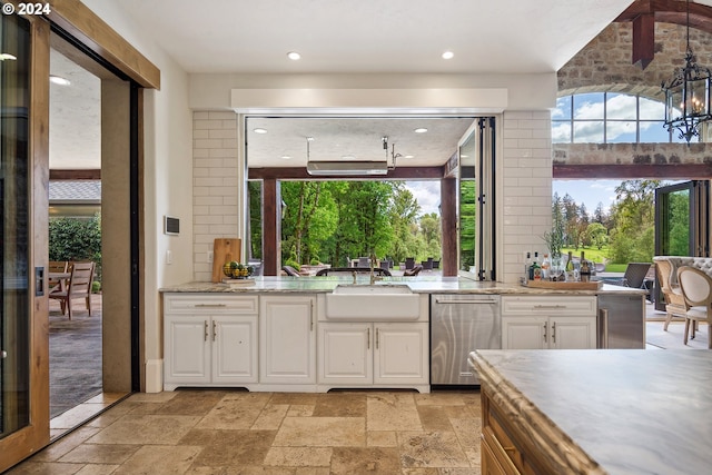 kitchen with white cabinetry, light stone countertops, a notable chandelier, sink, and dishwasher