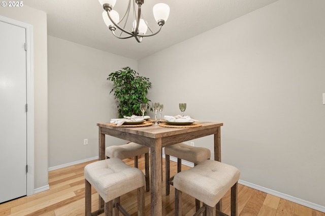 dining space featuring an inviting chandelier and light hardwood / wood-style flooring