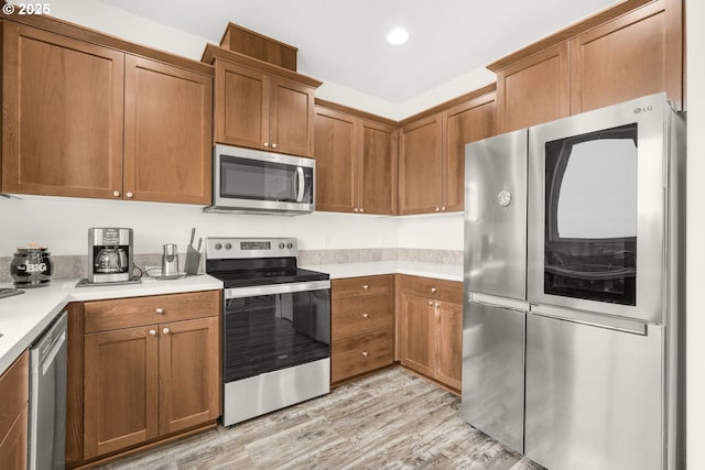 18385 Inglis Rd, Clatskanie, OR 97016 - kitchen with stainless steel appliances, light wood-style floors, light countertops, brown cabinetry, and recessed lighting