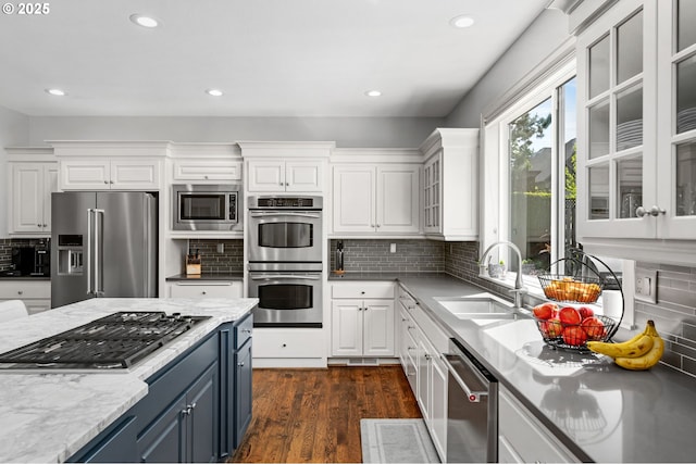 kitchen with stainless steel appliances, a sink, white cabinets, dark wood-style flooring, and recessed lighting