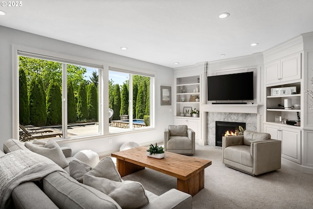 living area featuring light colored carpet, recessed lighting, a premium fireplace, and built in features