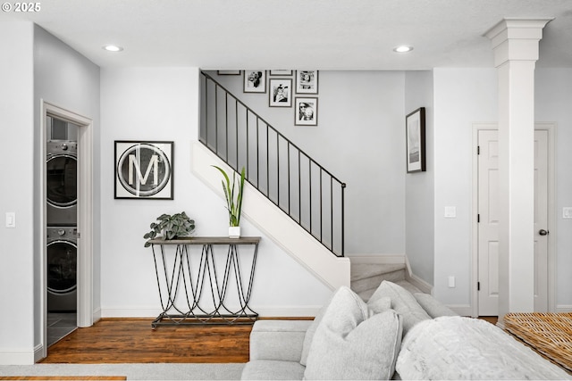 stairs featuring estacked washer and dryer, baseboards, recessed lighting, and wood finished floors