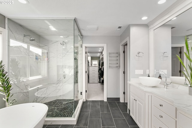 full bathroom with a marble finish shower, recessed lighting, a walk in closet, vanity, and a freestanding bath
