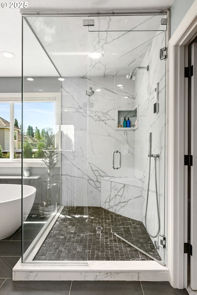 bathroom featuring a marble finish shower, a soaking tub, and recessed lighting