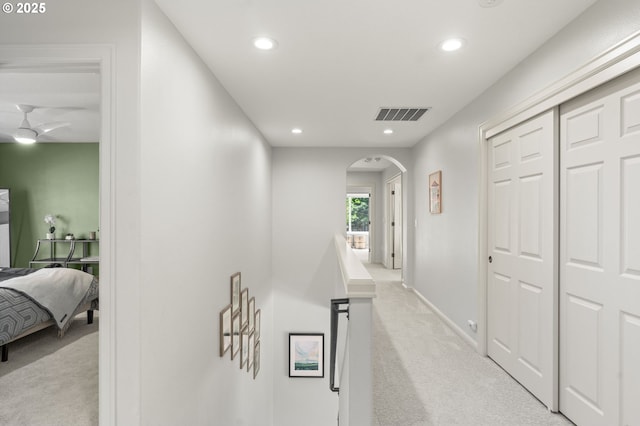 hall featuring carpet floors, arched walkways, recessed lighting, and baseboards
