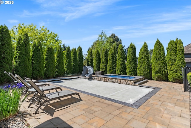 view of patio / terrace with an in-ground hot tub