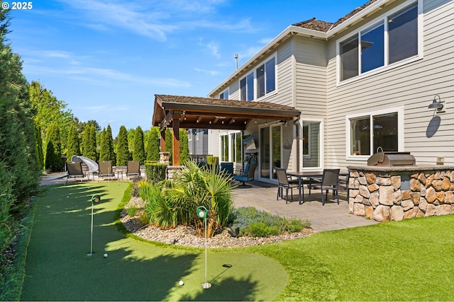 back of house with a patio area, an outdoor kitchen, and a putting area