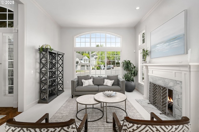 living area featuring ornamental molding, a premium fireplace, baseboards, and recessed lighting