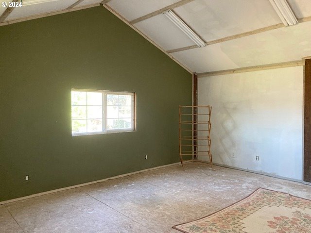 spare room featuring vaulted ceiling