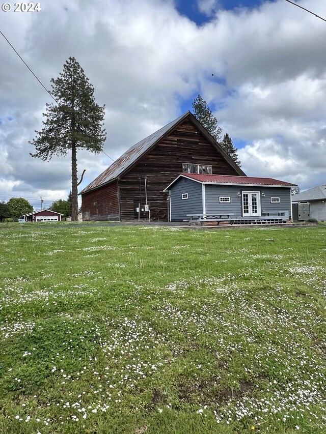 rear view of property with a yard and an outdoor structure