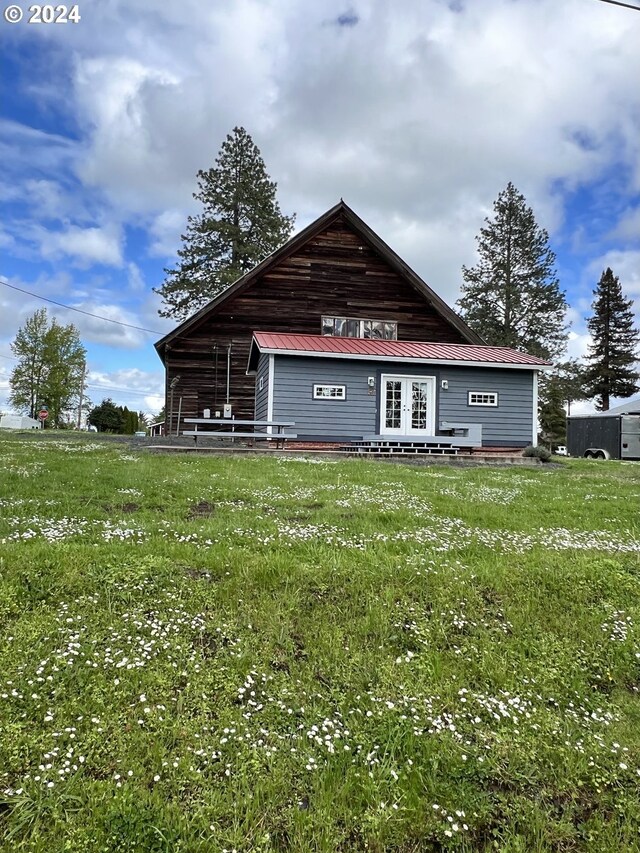 back of house with french doors and metal roof