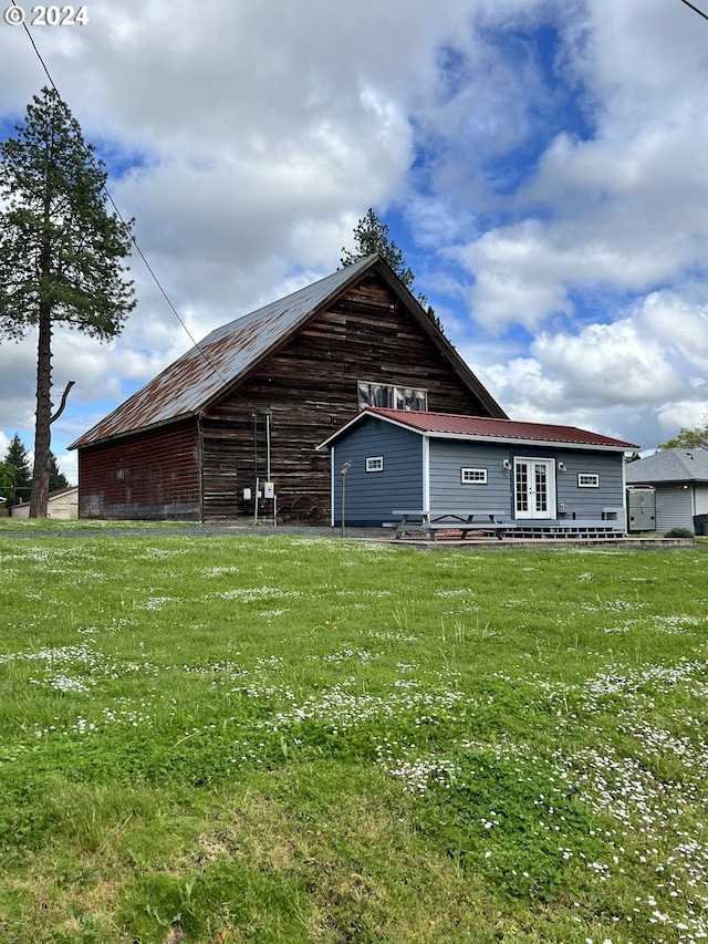 rear view of house featuring a yard, an outdoor structure, and a barn