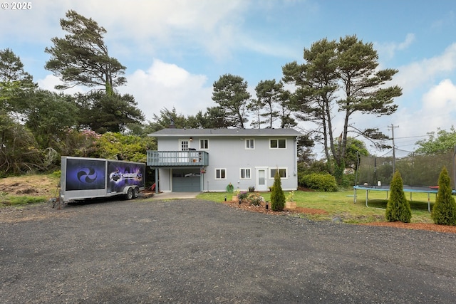 view of front facade featuring a deck, a garage, and a trampoline