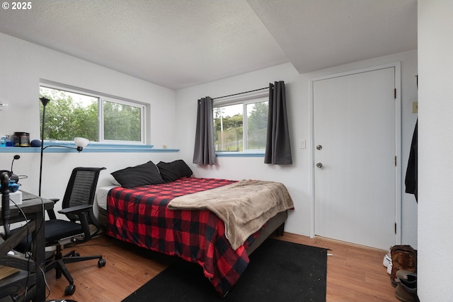 bedroom featuring light hardwood / wood-style floors and a textured ceiling