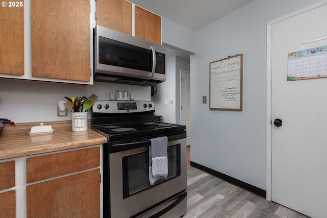 kitchen featuring appliances with stainless steel finishes and light hardwood / wood-style flooring