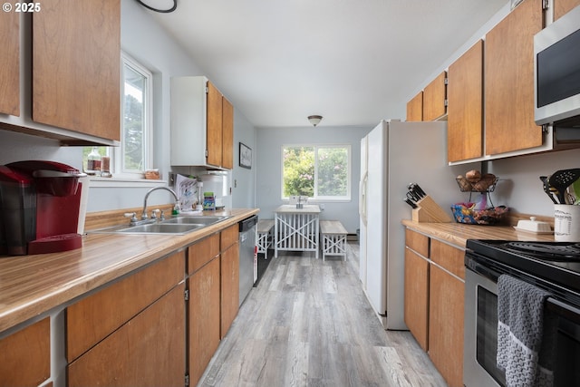 kitchen featuring stainless steel appliances, sink, plenty of natural light, and light hardwood / wood-style flooring