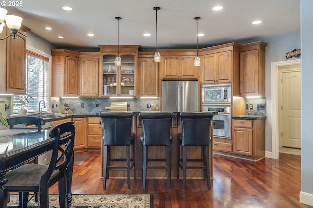 16572 SE Oak Meadow Ct, Damascus, OR 97089 - kitchen featuring stainless steel appliances, dark wood-style flooring, a center island, glass insert cabinets, and dark countertops