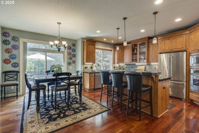 16572 SE Oak Meadow Ct, Damascus, OR 97089 - kitchen with stainless steel appliances, plenty of natural light, dark countertops, glass insert cabinets, and recessed lighting