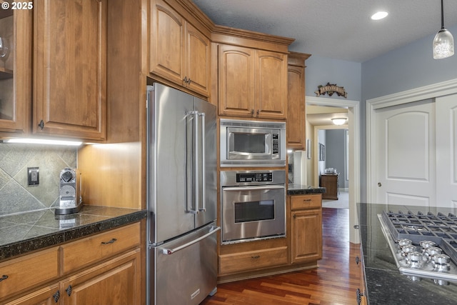 16572 SE Oak Meadow Ct, Damascus, OR 97089 - kitchen featuring stainless steel appliances, tile countertops, dark wood finished floors, tasteful backsplash, and brown cabinets