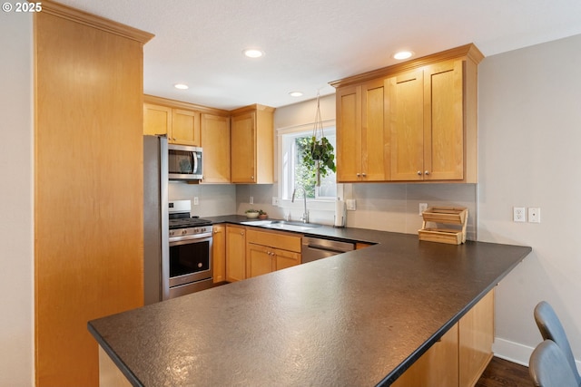 511 NE Skidmore St, Portland, OR 97211 - kitchen featuring stainless steel appliances, dark countertops, a peninsula, recessed lighting, and dark wood-style floors