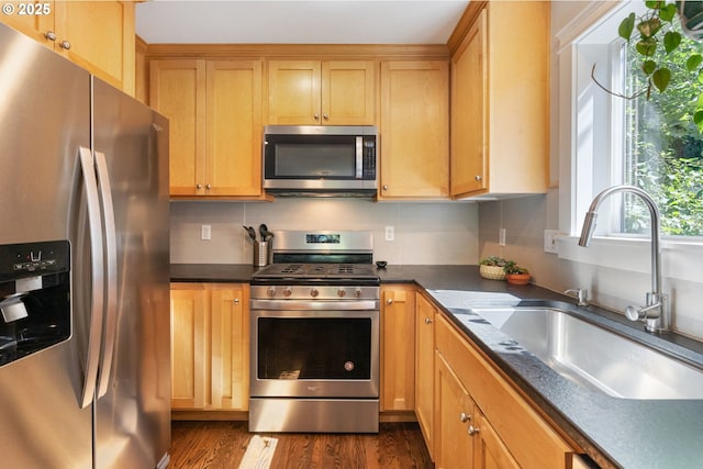 511 NE Skidmore St, Portland, OR 97211 - kitchen featuring appliances with stainless steel finishes, dark countertops, and dark wood finished floors