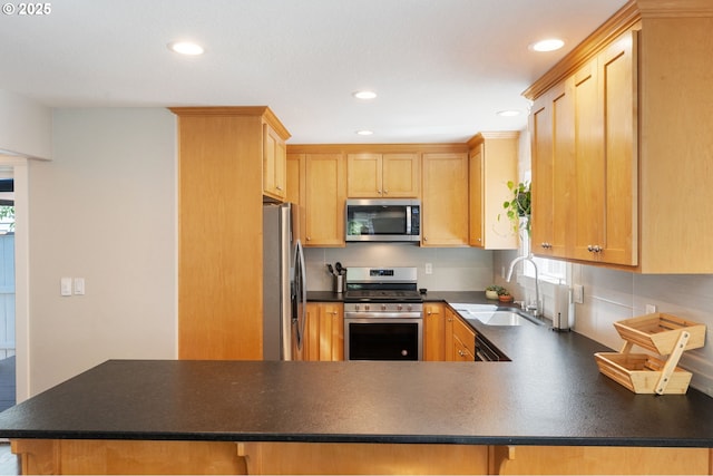 511 NE Skidmore St, Portland, OR 97211 - kitchen featuring appliances with stainless steel finishes, recessed lighting, dark countertops, plenty of natural light, and a peninsula