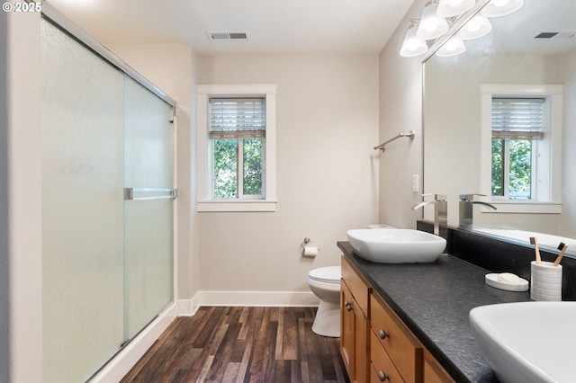 511 NE Skidmore St, Portland, OR 97211 - bathroom with wood finished floors, a shower stall, double vanity, and a chandelier