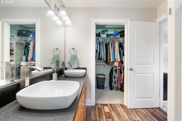 511 NE Skidmore St, Portland, OR 97211 - full bath featuring double vanity, wood finished floors, a walk in closet, and a chandelier