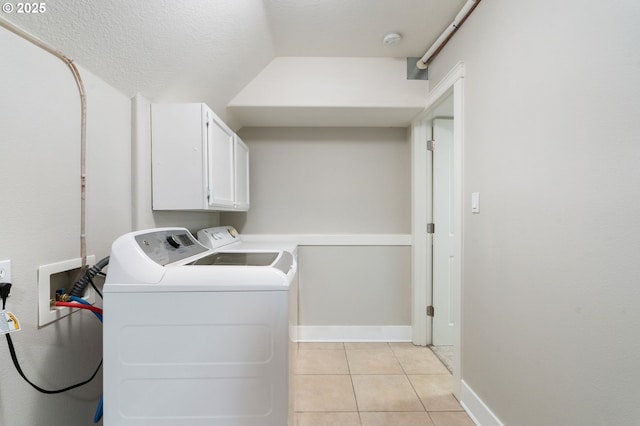 511 NE Skidmore St, Portland, OR 97211 - washroom featuring cabinet space, washer and clothes dryer, and light tile patterned floors