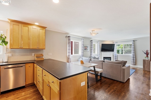 511 NE Skidmore St, Portland, OR 97211 - kitchen with stainless steel dishwasher, a peninsula, recessed lighting, dark wood-style flooring, and dark countertops