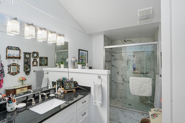 bathroom with lofted ceiling, vanity, a shower with door, and a textured ceiling