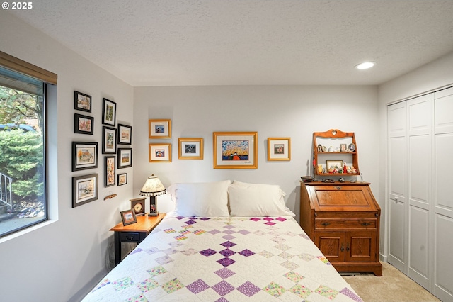 carpeted bedroom with a textured ceiling and a closet