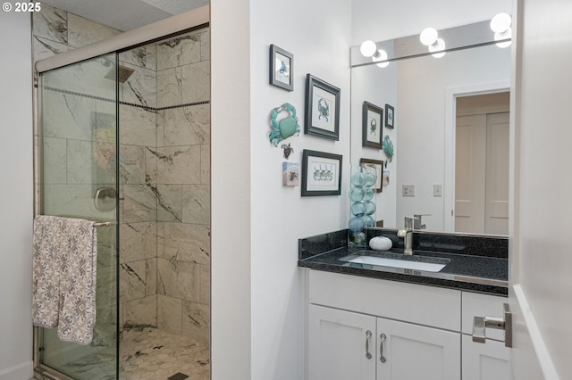 bathroom featuring a shower with shower door and vanity