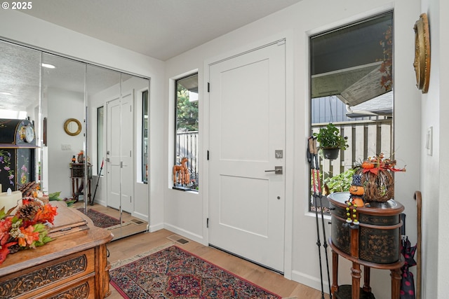 entrance foyer with light hardwood / wood-style floors and a textured ceiling