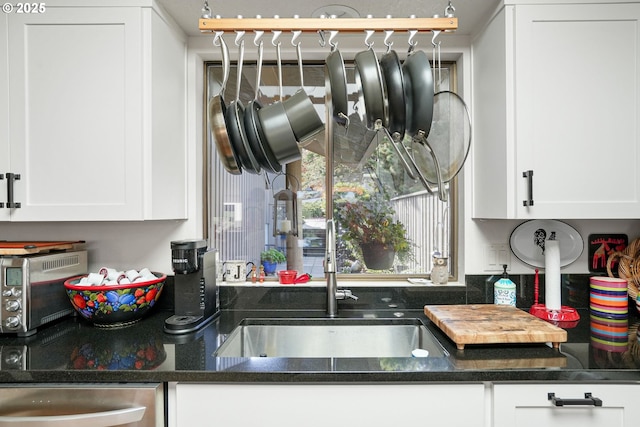 kitchen with white cabinets, dishwasher, and sink