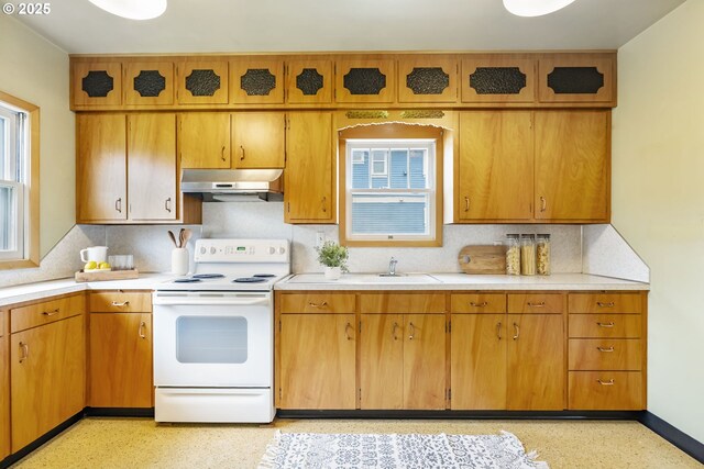 kitchen featuring under cabinet range hood, backsplash, light countertops, and electric stove